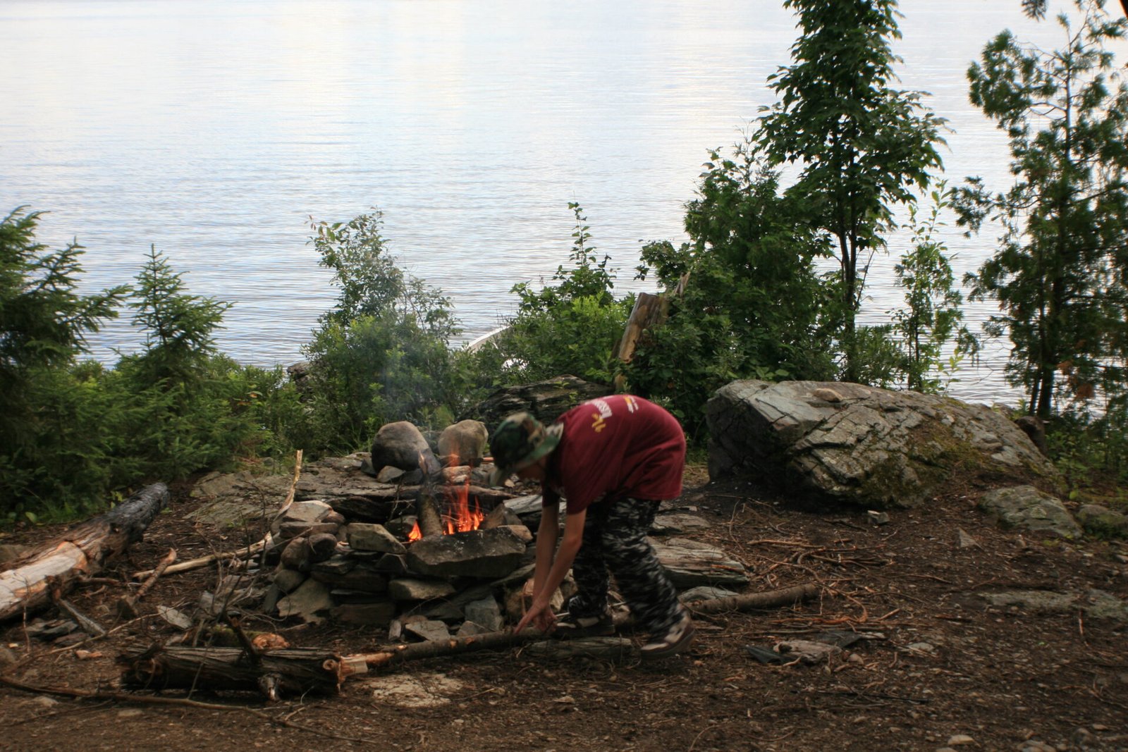Devin tending the campfire by Lake Temagami shoreline, 2008
