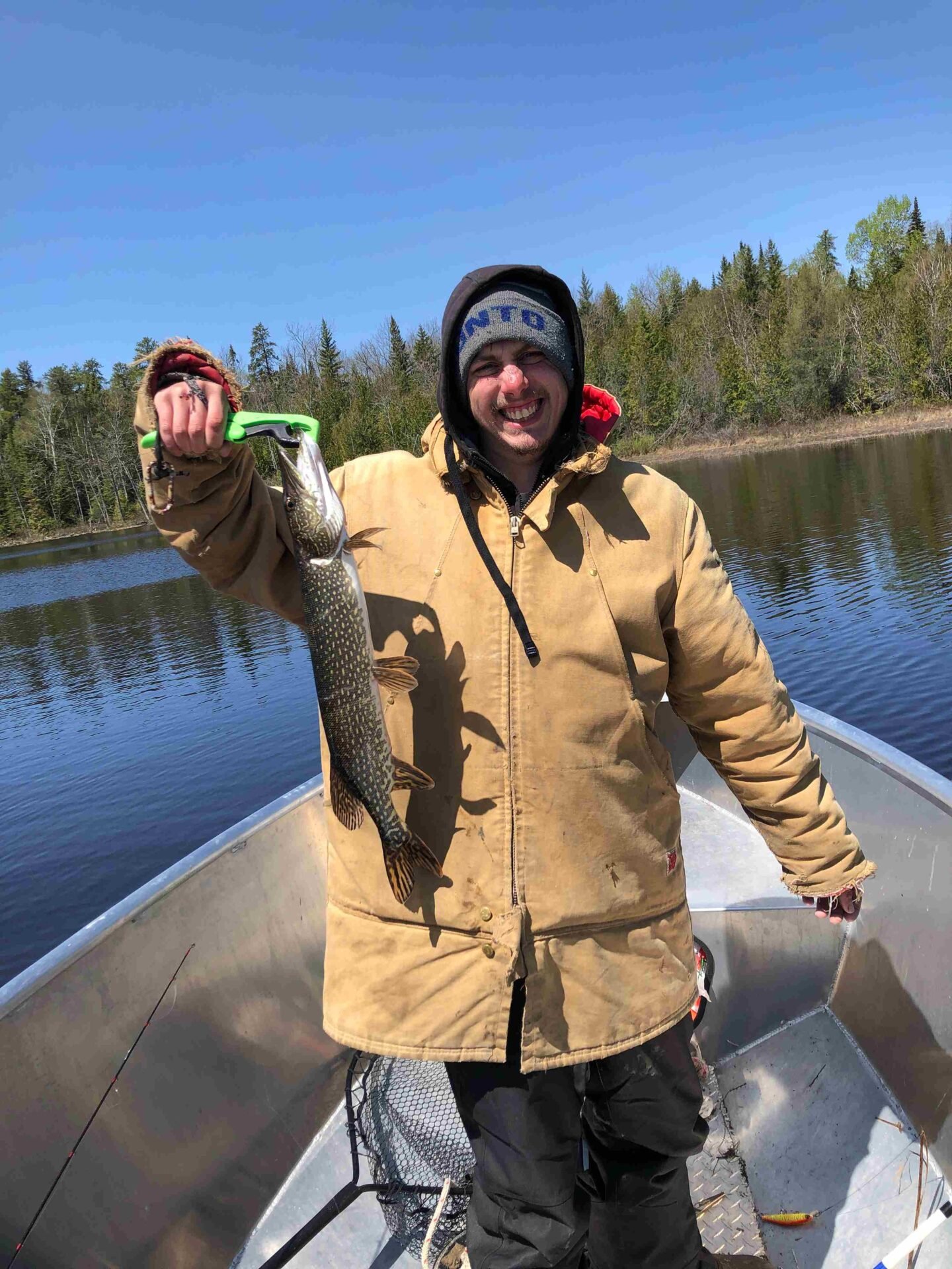 Devin holding a northern pike with a green lure on Dog Lake