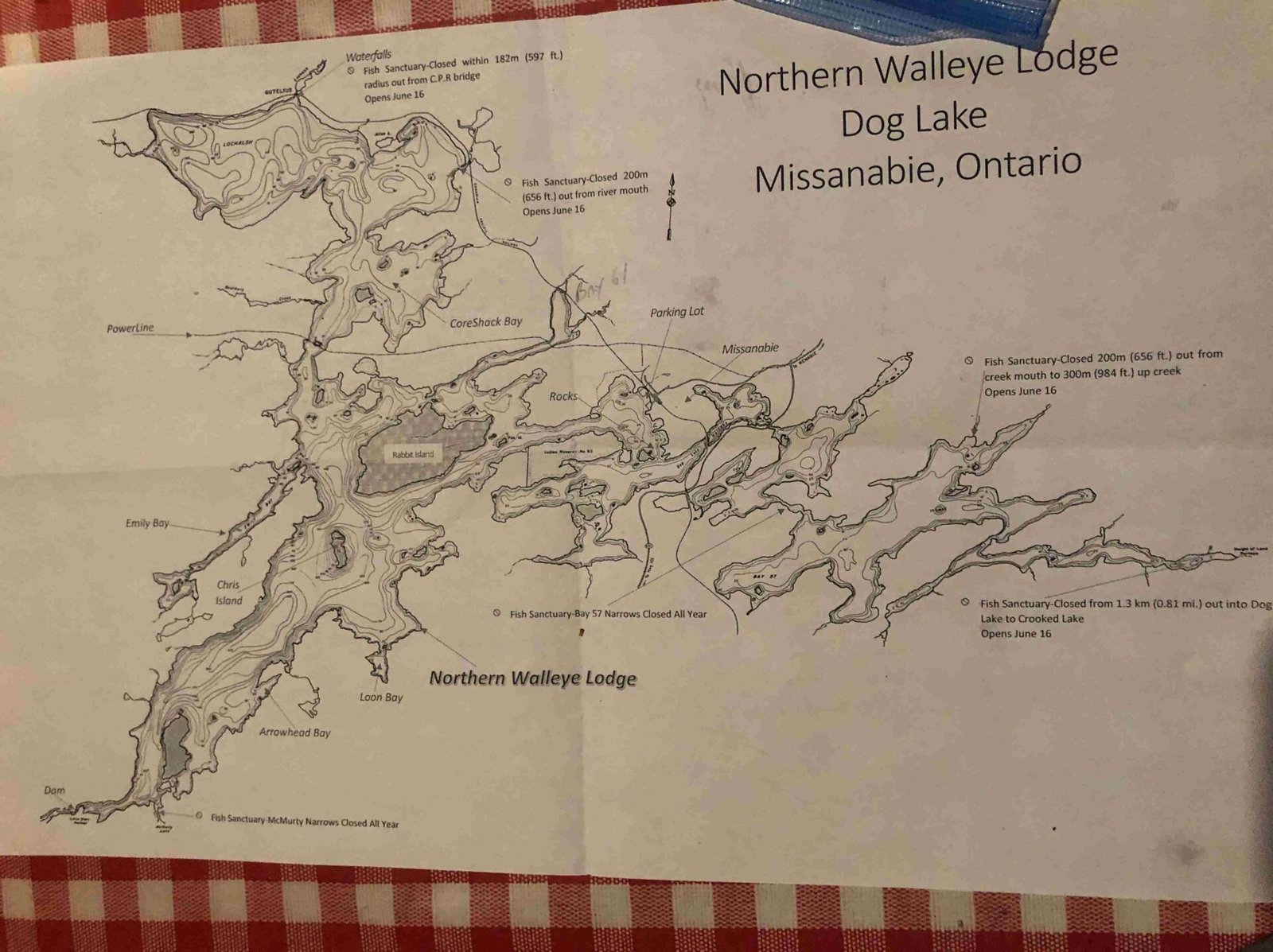 Hand-drawn lodge map of Dog Lake, Missanabie, Ontario, on a red checkered tablecloth