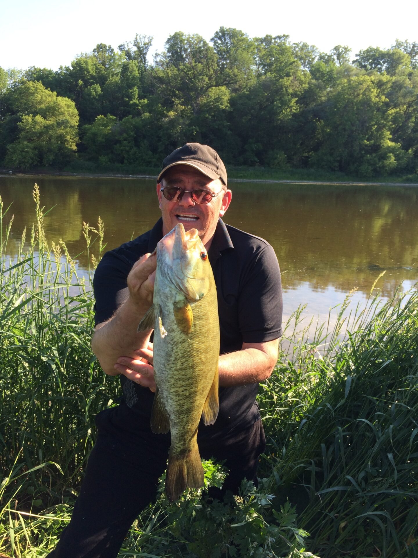 Don holding a smallmouth bass caught in the Grand River, Ontario